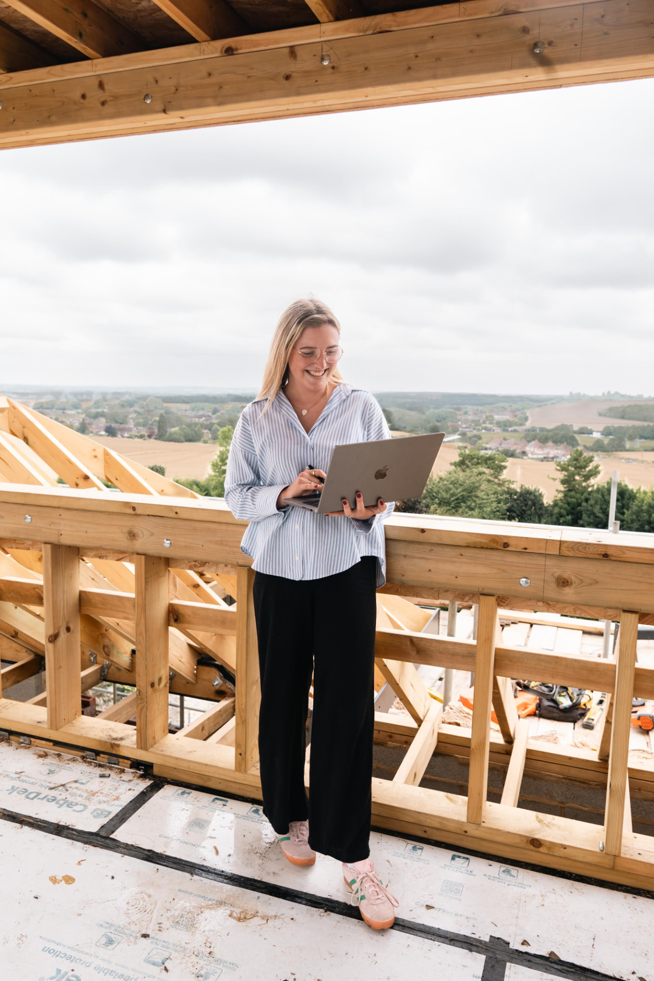 True Designs founder reviewing plans on a timber-framed build site